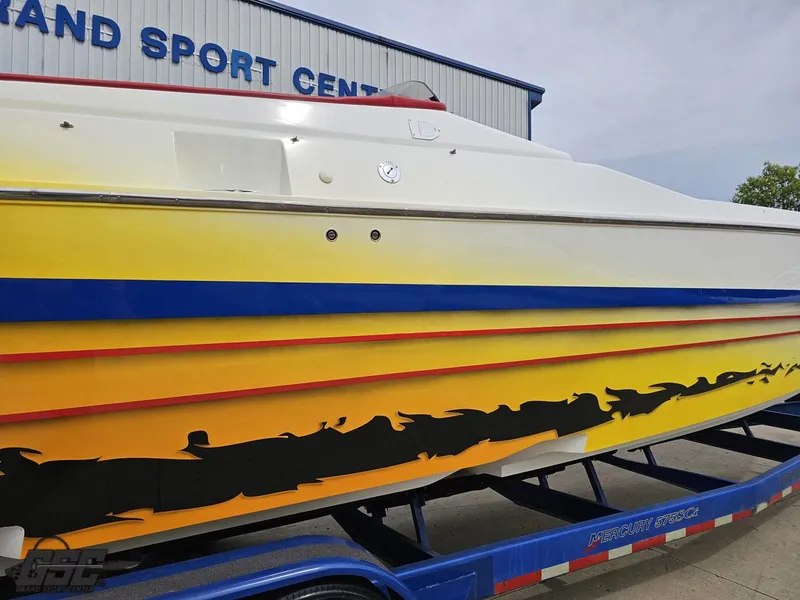 Slide: The Image of 2001 Cigarette 42 Tiger boat with vibrant yellow and blue design on a trailer. - 9