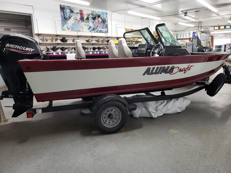 Slide: The Image of 2024 Alumacraft 165 SPT boat with Mercury engine on trailer in showroom. - 1