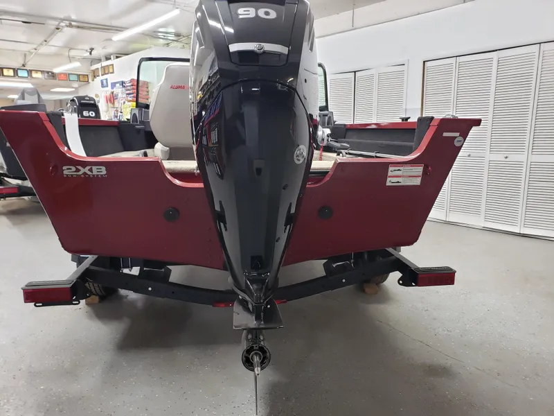 Slide: The Image of 2024 Alumacraft 165 SPT boat with 90 HP engine in showroom. - 2