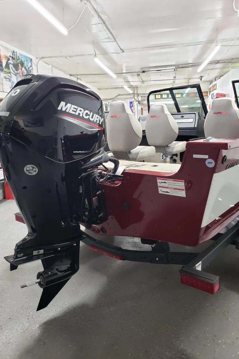 Slide: The Image of 2024 Alumacraft 165 SPT boat with Mercury engine in a garage setting. - 4