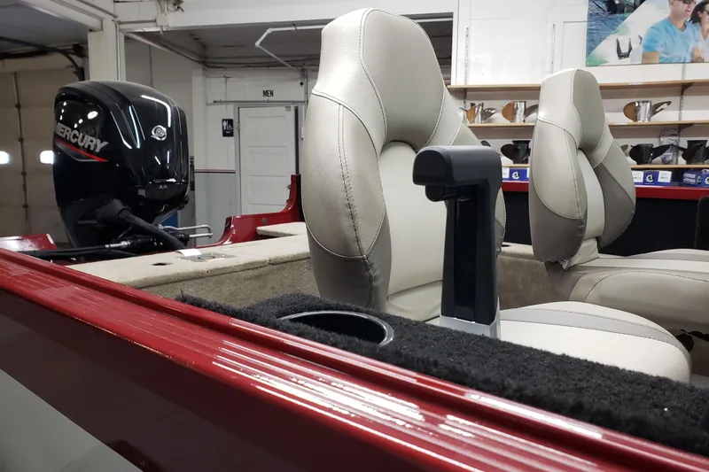 Slide: The Image of 2024 Alumacraft 165 SPT boat interior with Mercury engine, featuring beige seats and red trim. - 6