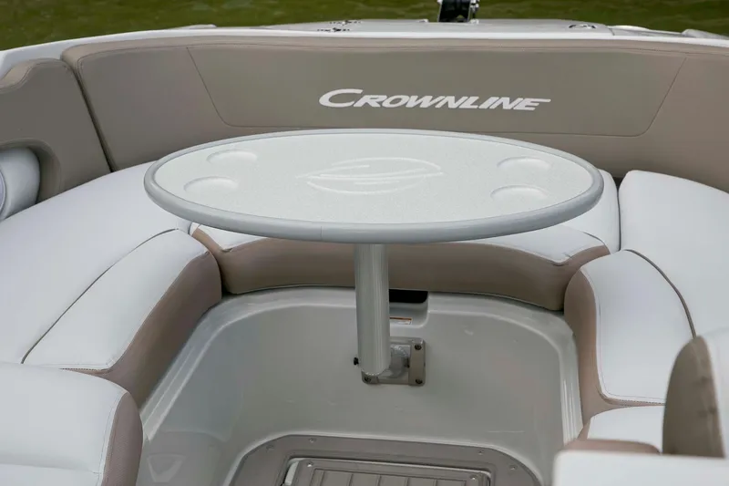 Slide: The Image of 2024 Crownline E305 boat interior with round table and cushioned seating. - 14