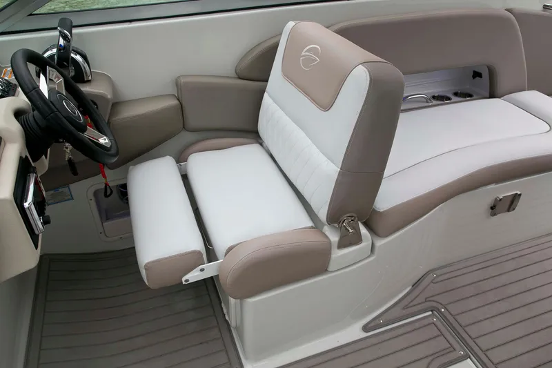 Slide: The Image of 2024 Crownline E305 boat interior with beige and white seating, steering wheel, and cup holders. - 16