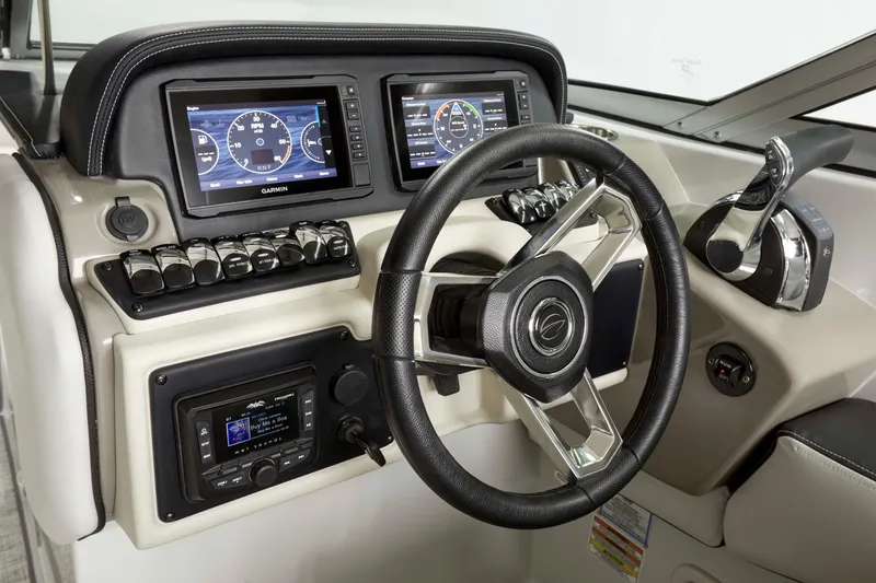 Slide: The Image of 2024 Crownline E305 boat dashboard with steering wheel and dual Garmin displays. - 6