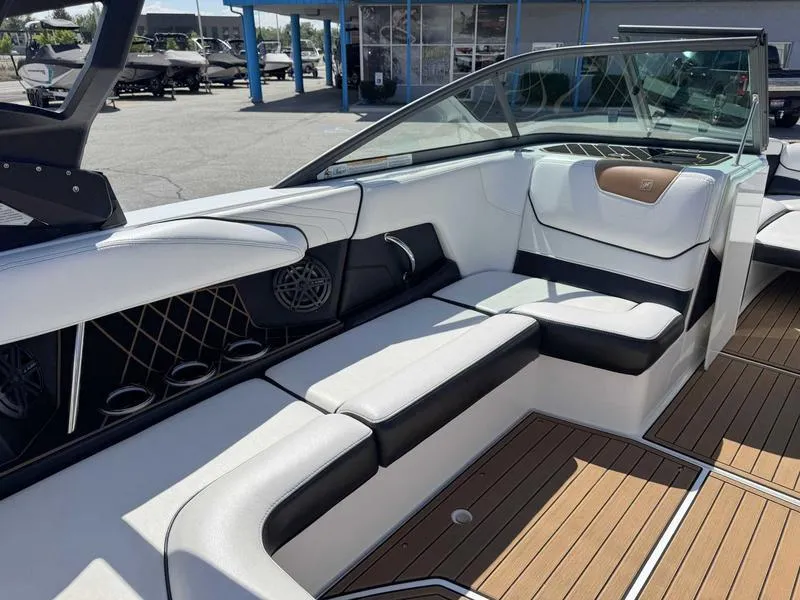 Slide: The Image of 2017 Nautique GS20 boat interior with white and black seating, wood flooring, and speaker system. - 5