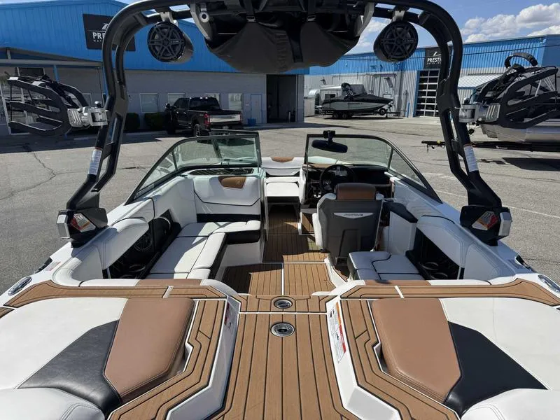 Slide: The Image of 2017 Nautique GS20 boat interior with seating and speakers, parked at a marina. - 8