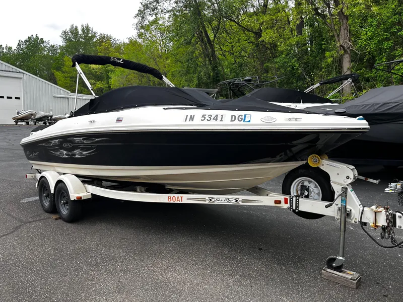 The Image of 2008 Sea Ray 205 Sport boat on trailer, parked outdoors with trees in background. - 1