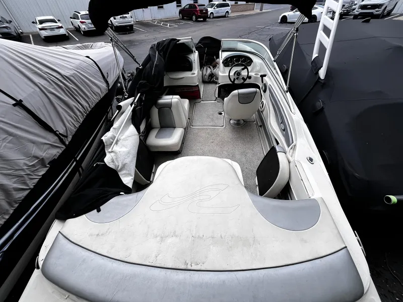 Slide: The Image of 2008 Sea Ray 205 Sport boat interior with seating and steering wheel, parked in a lot. - 6