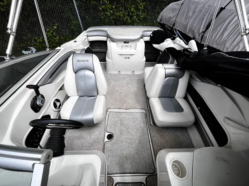 Slide: The Image of 2008 Sea Ray 205 Sport boat interior with gray and white seating, steering wheel, and covered canopy. - 8