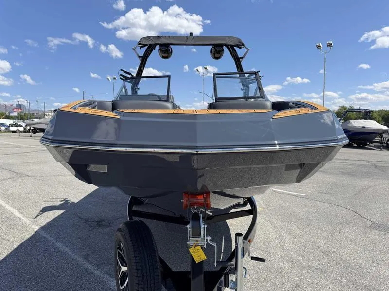 Slide: The Image of 2025 Moomba Max boat on trailer under clear blue sky. - 11