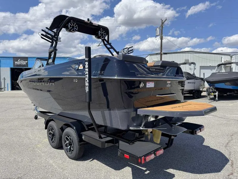 Slide: The Image of 2025 Moomba Max boat on trailer, parked outdoors under a blue sky. - 6