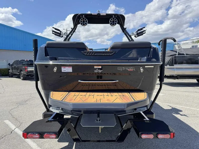 Slide: The Image of 2025 Moomba Max boat rear view in a parking lot under a blue sky. - 8