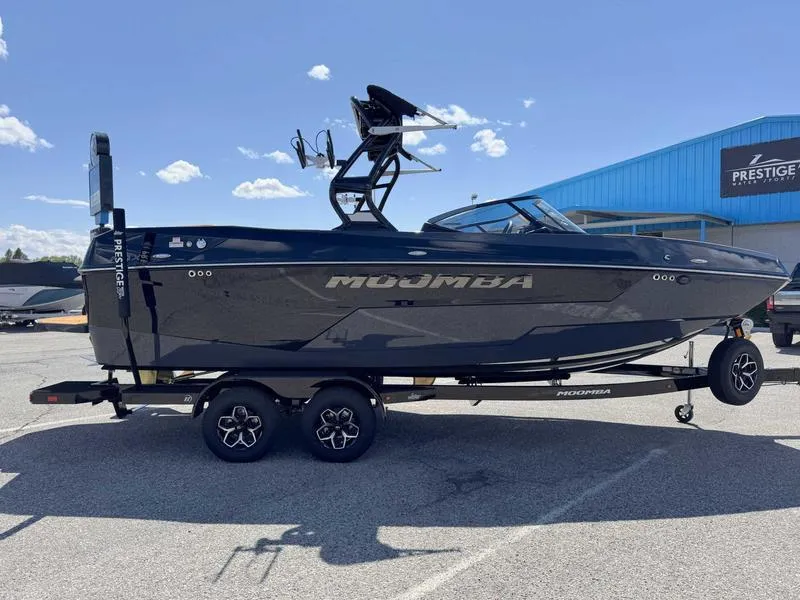 Slide: The Image of 2025 Moomba Max boat on trailer, parked outdoors under a clear blue sky. - 9