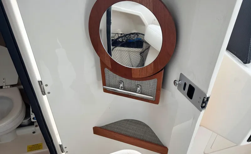 Slide: The Image of 2017 Grady-White Freedom 275 boat interior with round mirror and storage compartment. - 10