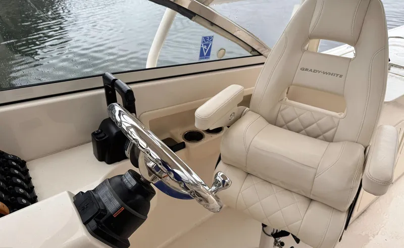 Slide: The Image of 2017 Grady-White Freedom 275 boat interior with steering wheel and cushioned seat. - 12