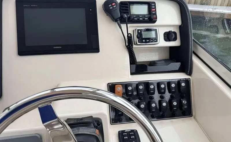 Slide: The Image of Control panel of 2017 Grady-White Freedom 275 boat with steering wheel and electronic displays. - 13