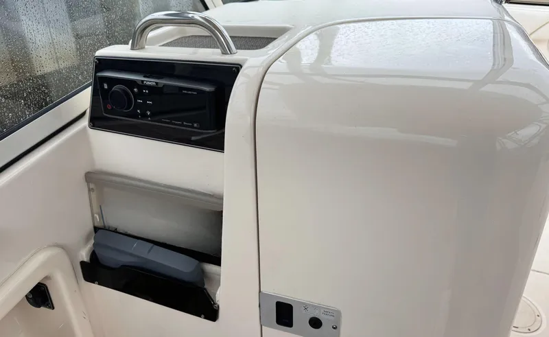 Slide: The Image of 2017 Grady-White Freedom 275 boat interior with stereo system and storage compartment. - 8