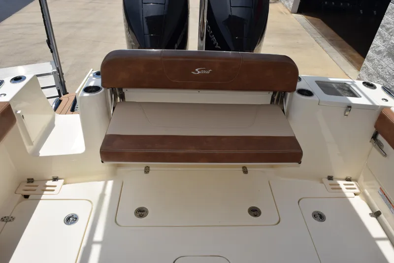 Slide: The Image of 2023 Scout 277 Dorado boat interior with brown seating and dual engines. - 12
