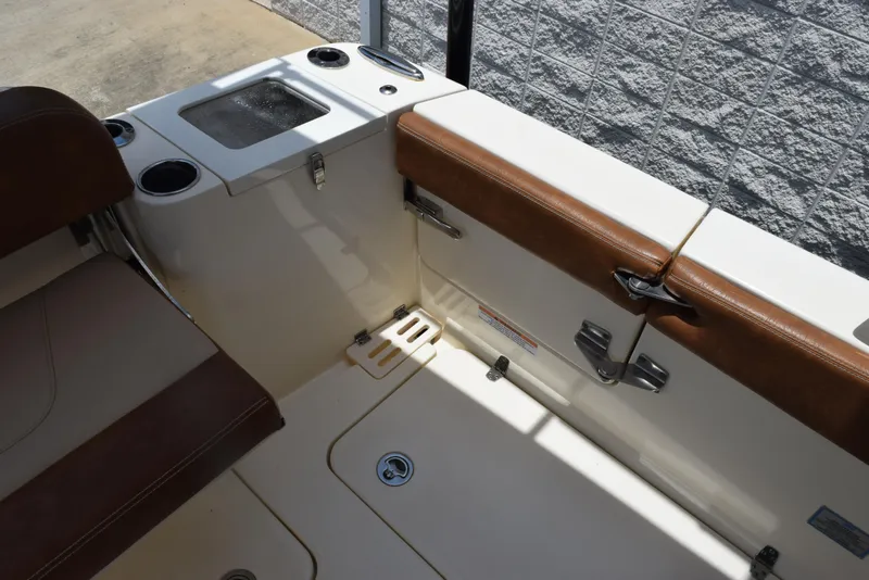 Slide: The Image of 2023 Scout 277 Dorado boat interior with brown seating and storage compartments. - 13