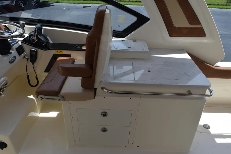 Slide: The Image of 2023 Scout 277 Dorado boat interior with brown seating and control panel. - 15