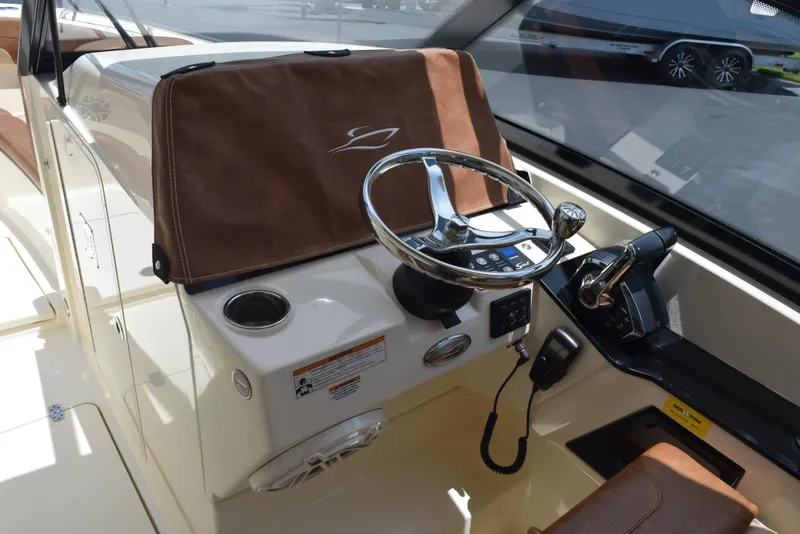 Slide: The Image of 2023 Scout 277 Dorado boat helm with steering wheel and control panel. - 16