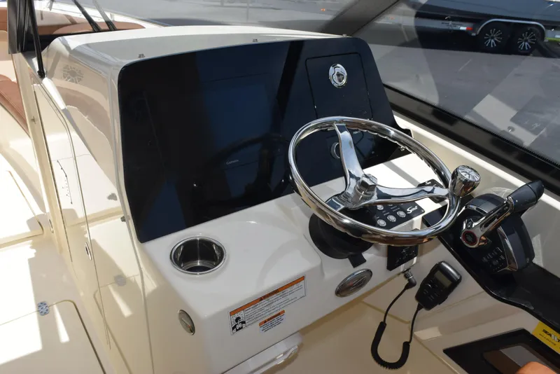Slide: The Image of 2023 Scout 277 Dorado boat dashboard with steering wheel and controls. - 18