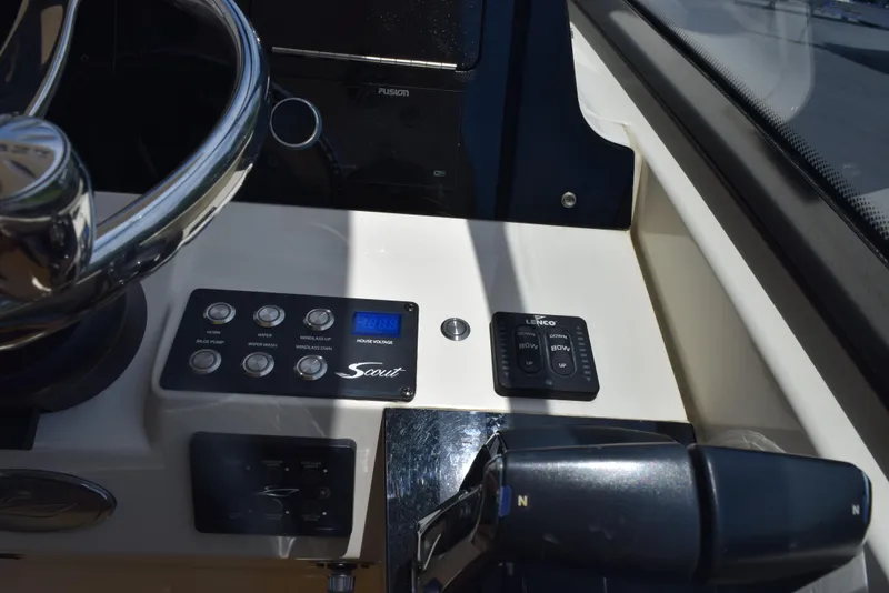 Slide: The Image of 2023 Scout 277 Dorado boat dashboard with controls and steering wheel. - 19