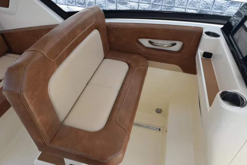 Slide: The Image of 2023 Scout 277 Dorado boat interior with brown leather seating and cup holders. - 25