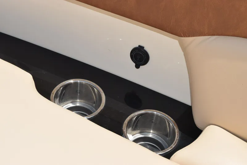 Slide: The Image of 2023 Scout 277 Dorado boat interior with cup holders and beige seating. - 38