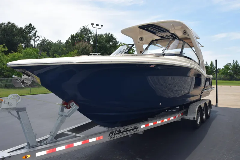 Slide: The Image of 2023 Scout 277 Dorado boat on a trailer, parked outdoors. - 4