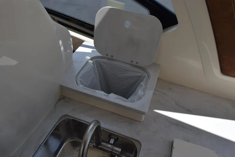 Slide: The Image of 2023 Scout 277 Dorado boat interior with sink and trash compartment. - 47