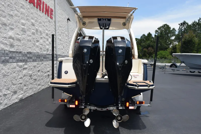 Slide: The Image of 2023 Scout 277 Dorado boat with dual outboard engines, parked on a paved surface. - 6