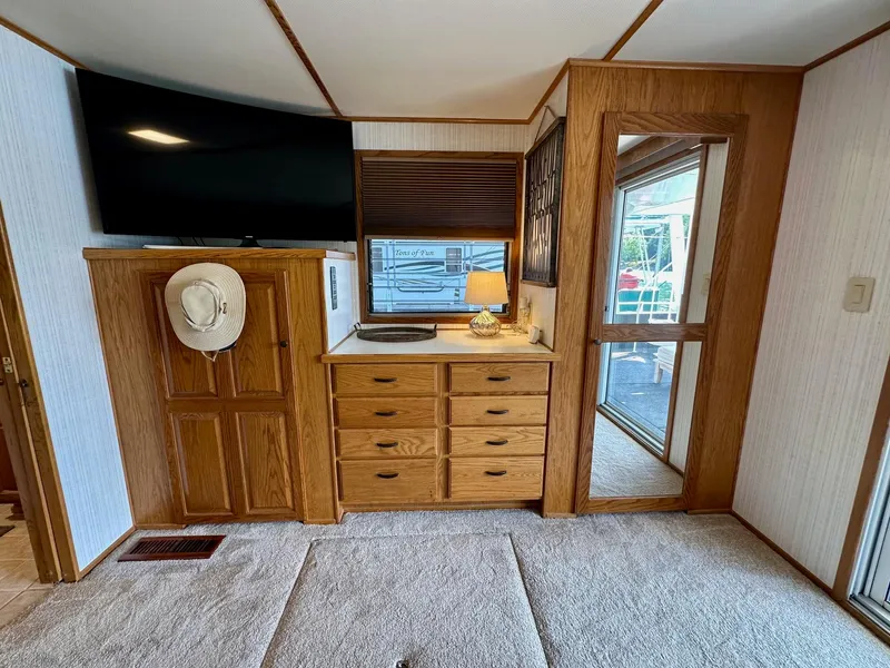 Slide: The Image of Interior of 1995 Lazy Days 16x75 houseboat with wooden cabinets, TV, and window. - 11