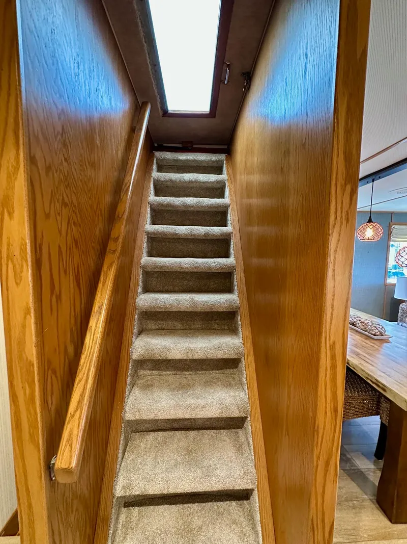 Slide: The Image of Carpeted stairs with wooden railing inside a 1995 Lazy Days 16x75 houseboat. - 13