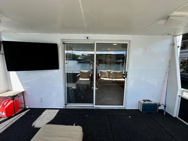 Slide: The Image of Houseboat interior with sliding glass doors, TV, and lake view; Lazy Days 16x75, 1995 model. - 15