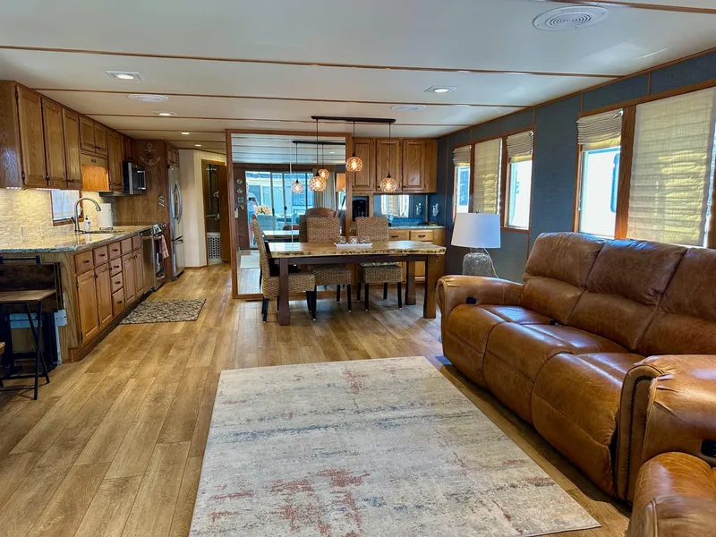 Slide: The Image of Spacious 1995 Lazy Days 16x75 houseboat interior with modern kitchen, dining area, and cozy seating. - 2