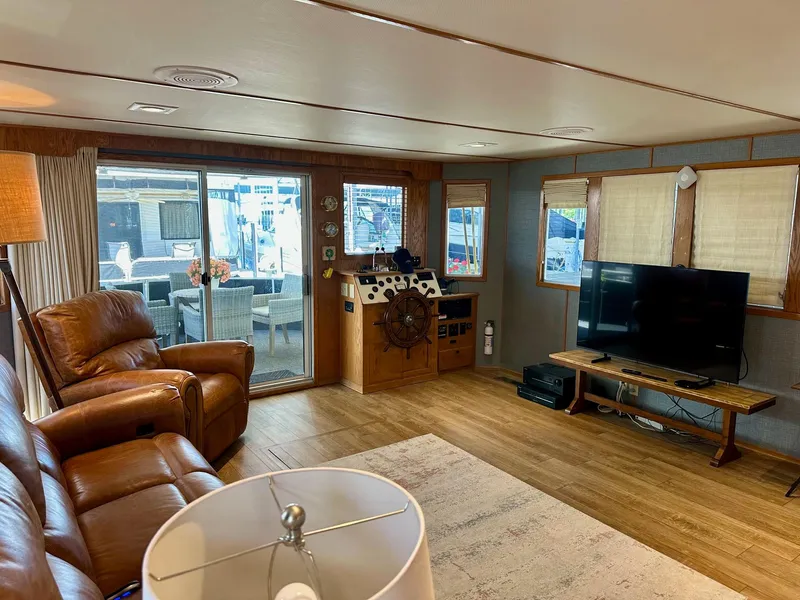 Slide: The Image of Spacious 1995 Lazy Days 16x75 houseboat interior with leather seating, TV, and large windows. - 3