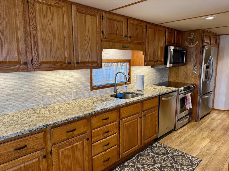 Slide: The Image of Spacious kitchen in 1995 Lazy Days 16x75 houseboat with wooden cabinets and modern appliances. - 4