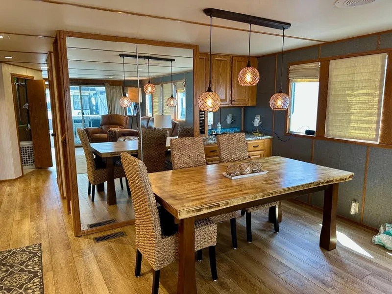 Slide: The Image of Dining area in a 1995 Lazy Days 16x75 houseboat with wooden table and wicker chairs. - 5