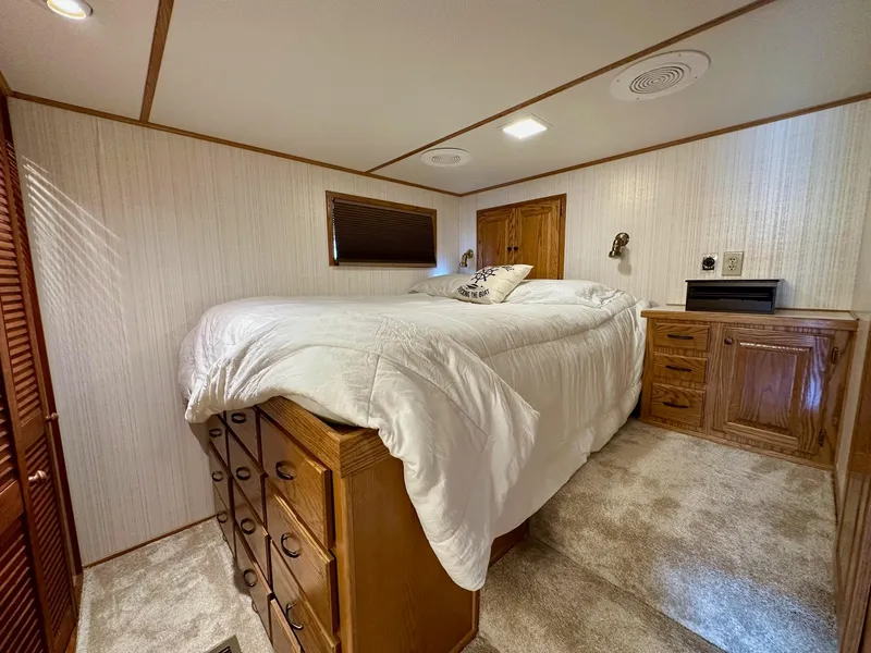 Slide: The Image of Cozy bedroom in 1995 Lazy Days 16x75 houseboat with wood cabinetry and plush carpeting. - 6