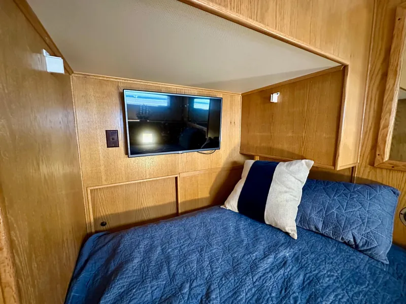 Slide: The Image of Cozy bedroom in 1995 Lazy Days 16x75 houseboat with TV and blue bedding. - 8