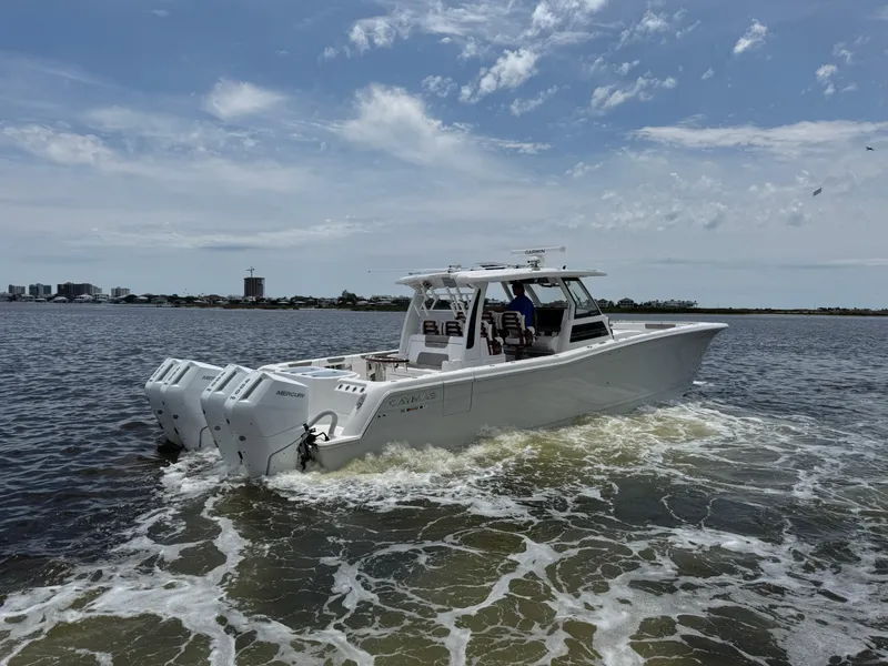 Slide: The Image of 2026 Caymas 44 CT boat cruising on open water under a partly cloudy sky. - 10