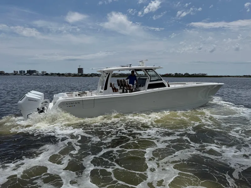 Slide: The Image of 2026 Caymas 44 CT boat cruising on open water under a partly cloudy sky. - 11