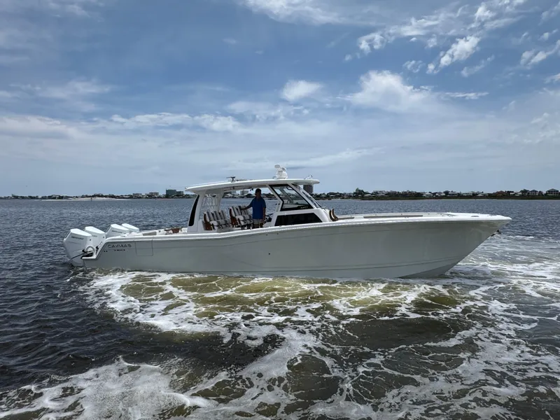 Slide: The Image of 2026 Caymas 44 CT boat cruising on open water under a partly cloudy sky. - 12