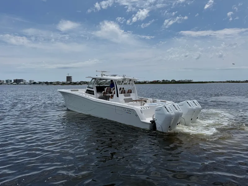 Slide: The Image of 2026 Caymas 44 CT boat cruising on a calm lake under a partly cloudy sky. - 14