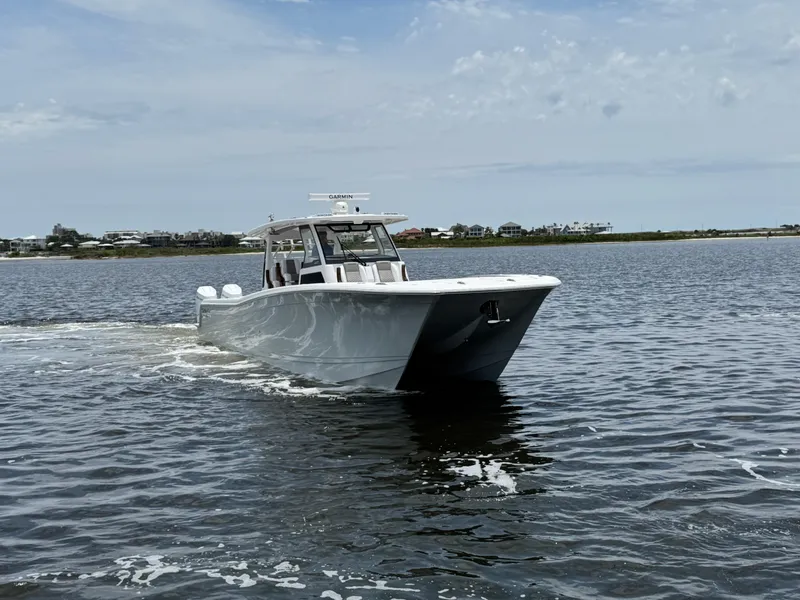 Slide: The Image of 2026 Caymas 44 CT boat cruising on open water under a cloudy sky. - 15