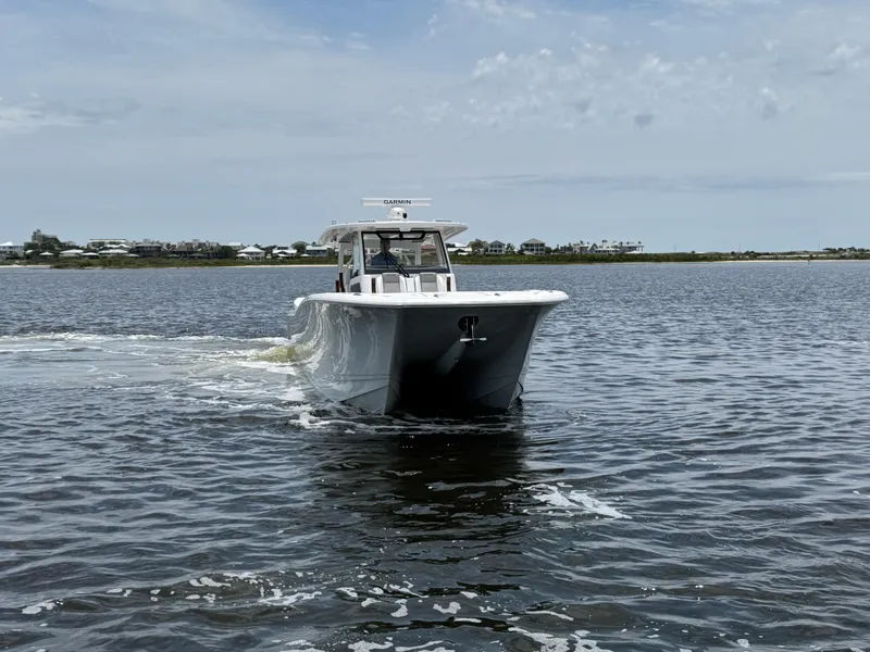 Slide: The Image of 2026 Caymas 44 CT boat cruising on open water under a cloudy sky. - 16