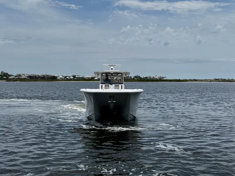 Slide: The Image of 2026 Caymas 44 CT boat cruising on calm waters under a cloudy sky. - 17