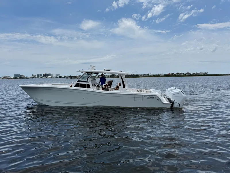 Slide: The Image of 2026 Caymas 44 CT boat on calm water under a partly cloudy sky. - 2