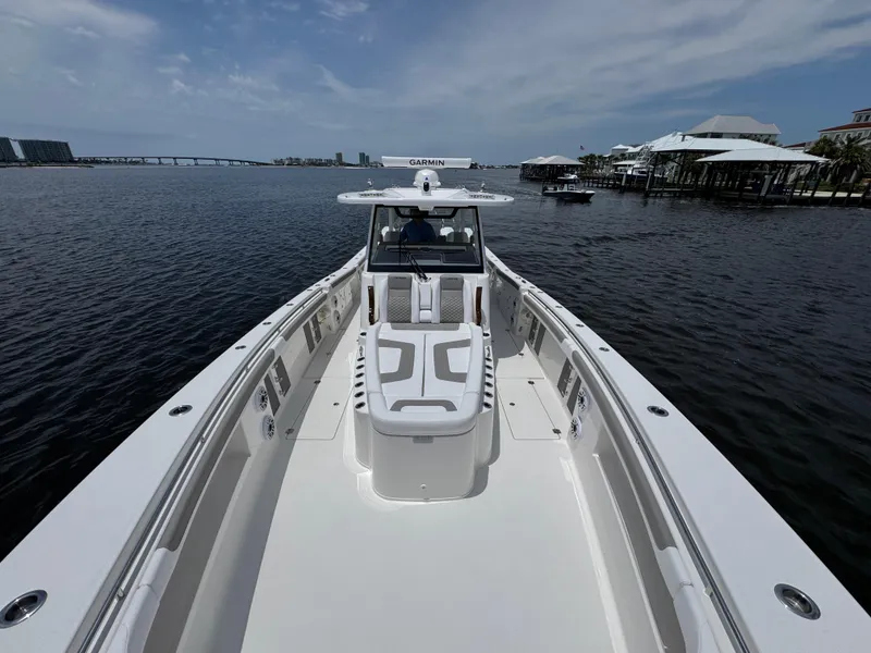 Slide: The Image of 2026 Caymas 44 CT boat on calm water with clear sky and distant bridge. - 21